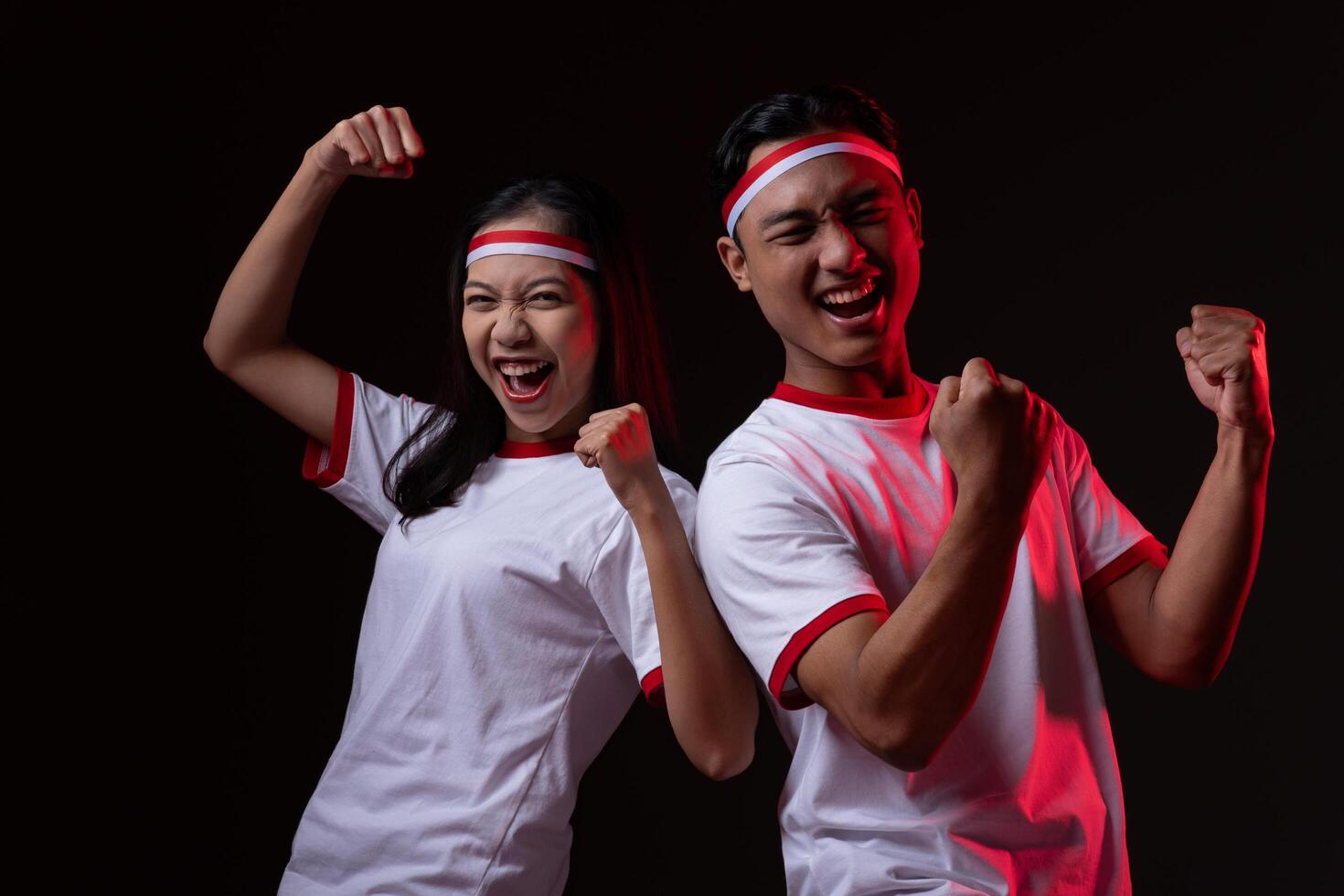 Portrait of Excited Young Asian Man and Woman Wearing Red White Outfit, Indonesian Independence Day Concept Isolated photo