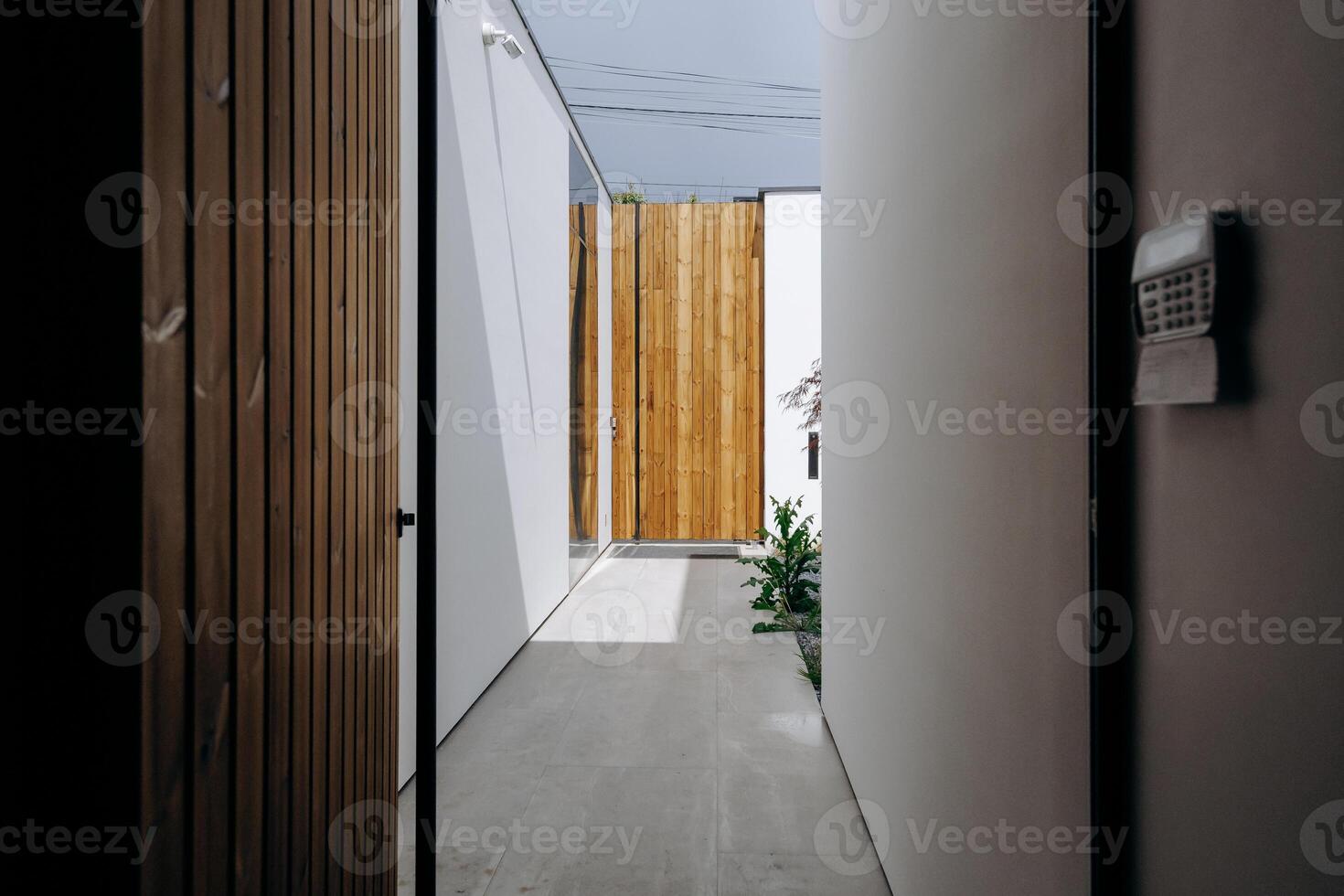 There is a hallway featuring a wooden door and a mailbox mounted on the wall photo