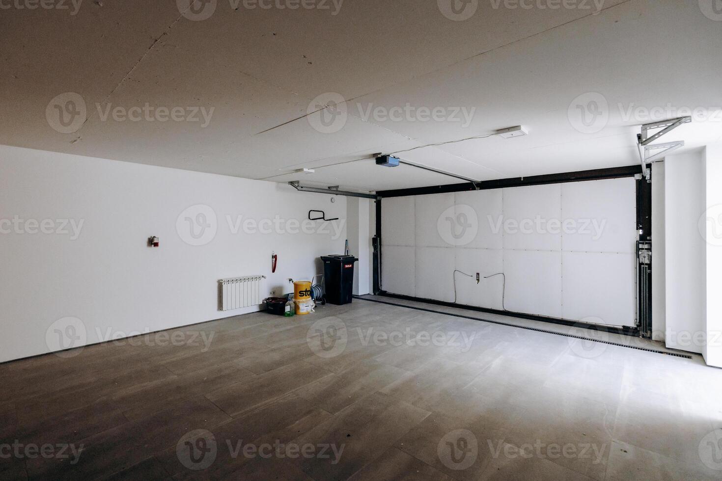 The garage is empty and features a sliding garage door for access photo