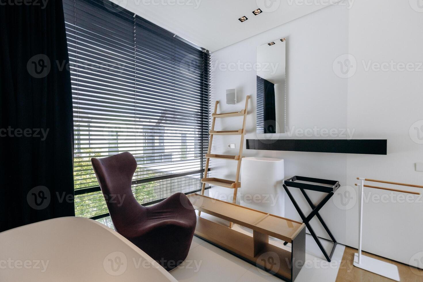 A cozy room with a simple chair and a tall ladder positioned in it photo