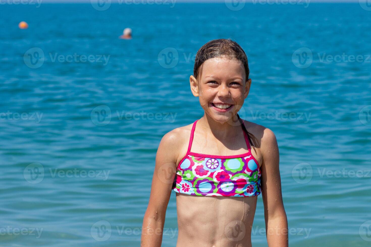 Caucasian happy and smiling child of 8 9 years going to swim in blue sea looking at camera photo