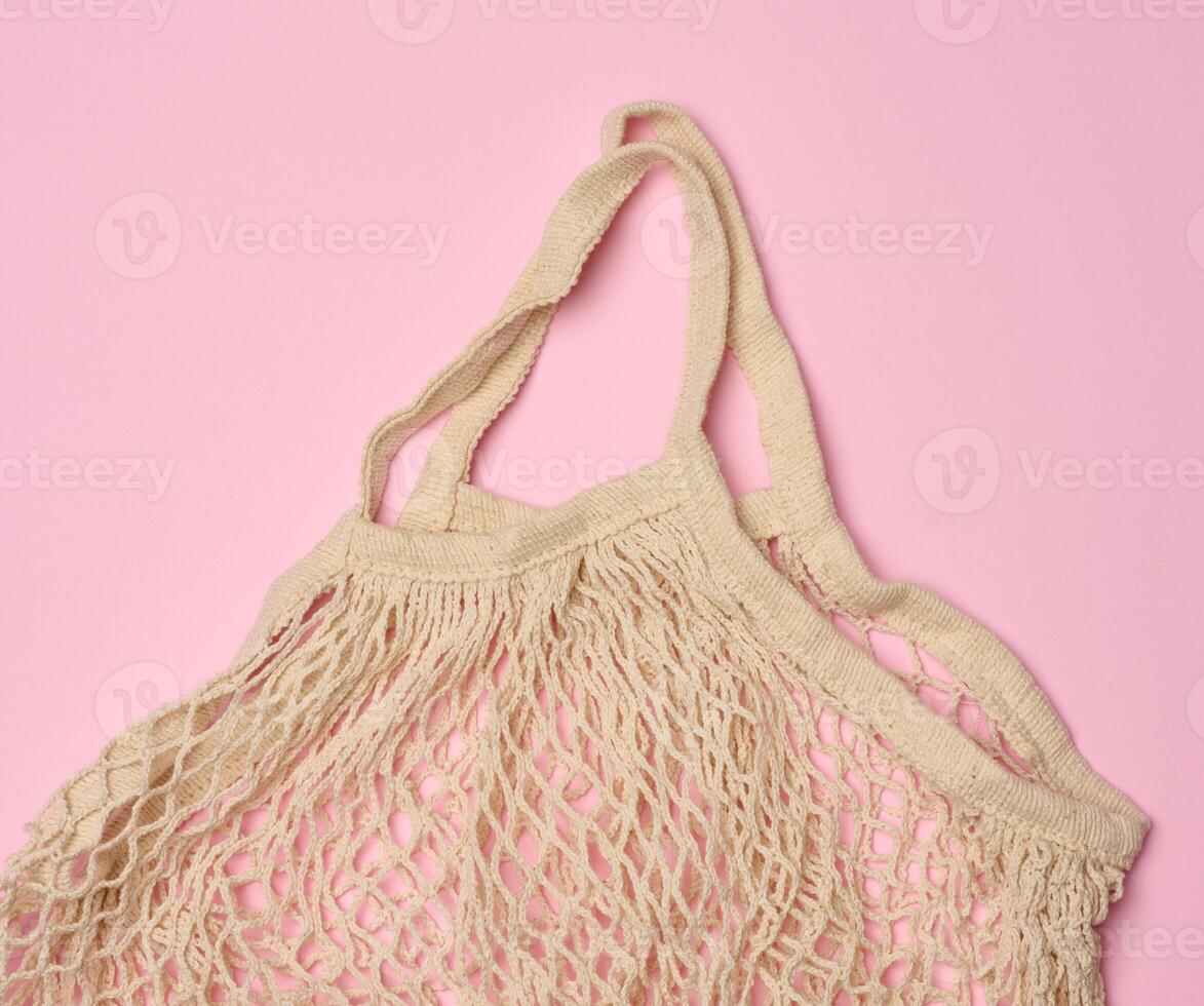 Empty reusable cotton mesh bag on pink background photo