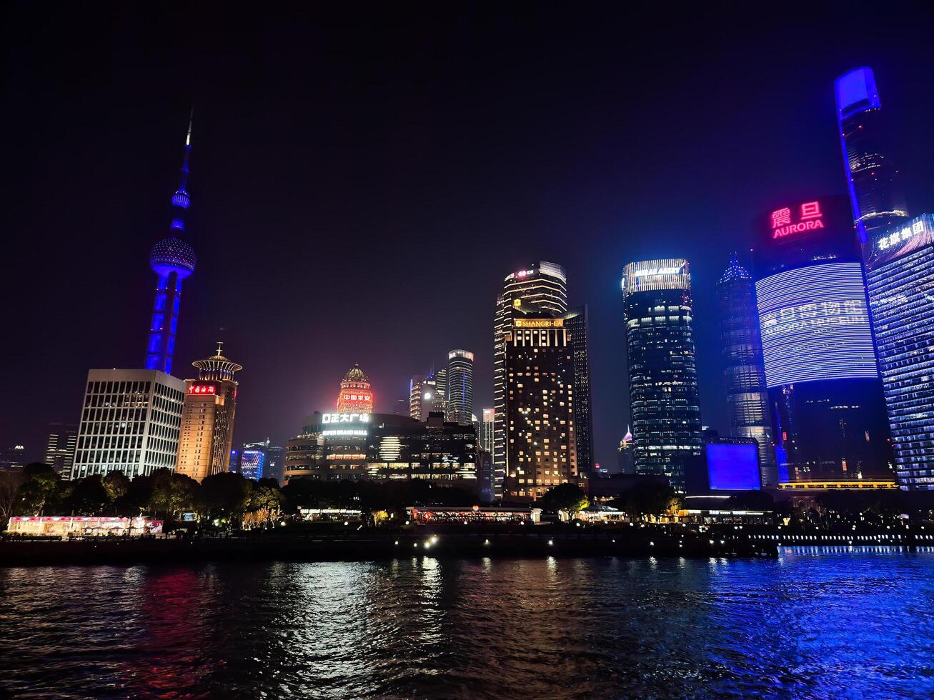 Shanghai, China - 1 April 2025 Colorful night skyline of Pudong with illuminated skyscrapers and reflections on the Huangpu River, viewed from the Bund. photo