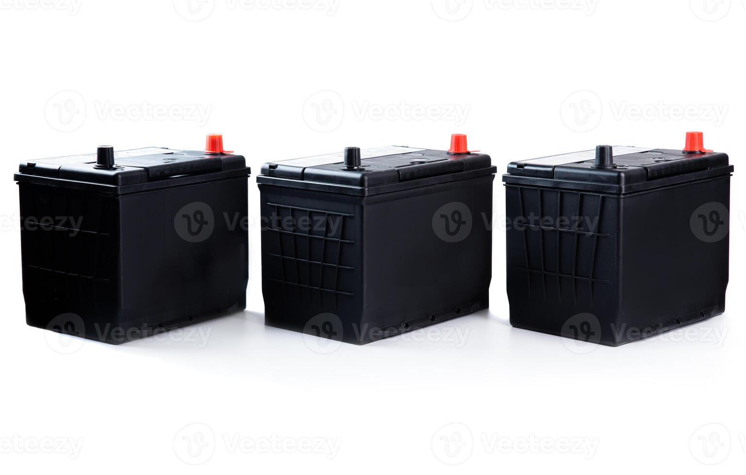 Three identical black car batteries in a row on white background. Isolated automotive parts for passenger vehicle repair, catalog, or store use. photo