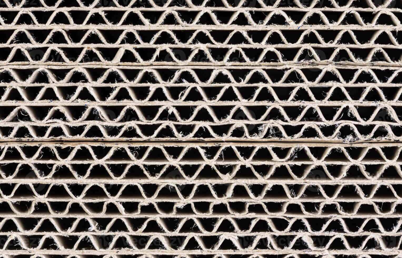 Close-up of stacked corrugated cardboard cross-sections showing wavy inner structure photo