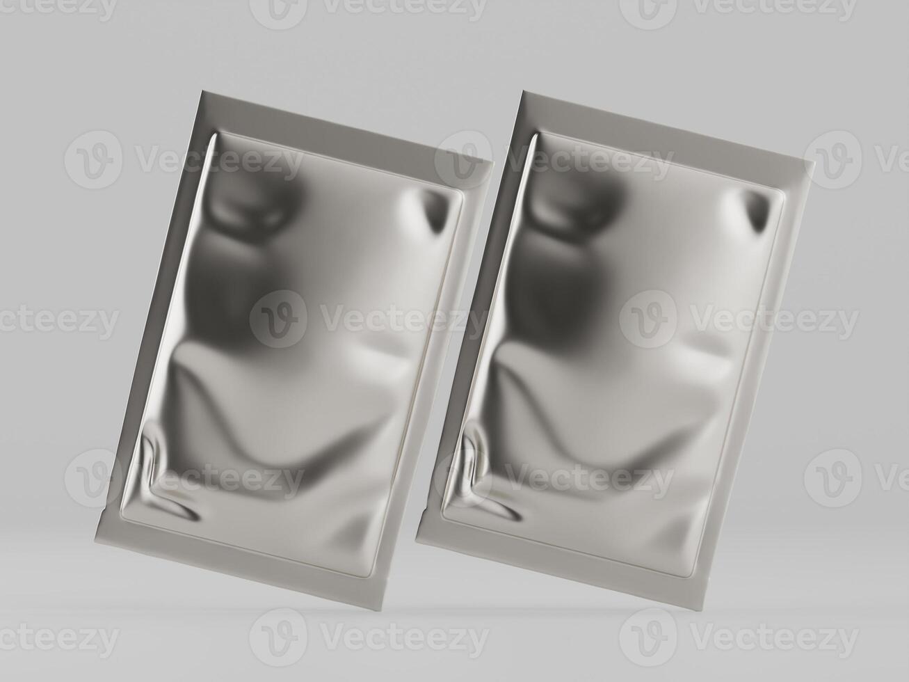 Two silver foil packets on a white surface photo