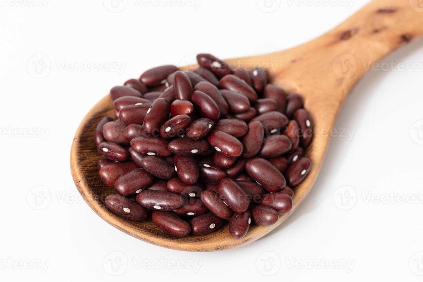 Close-up of a wooden spoon with raw red kidney beans isolated on white background photo