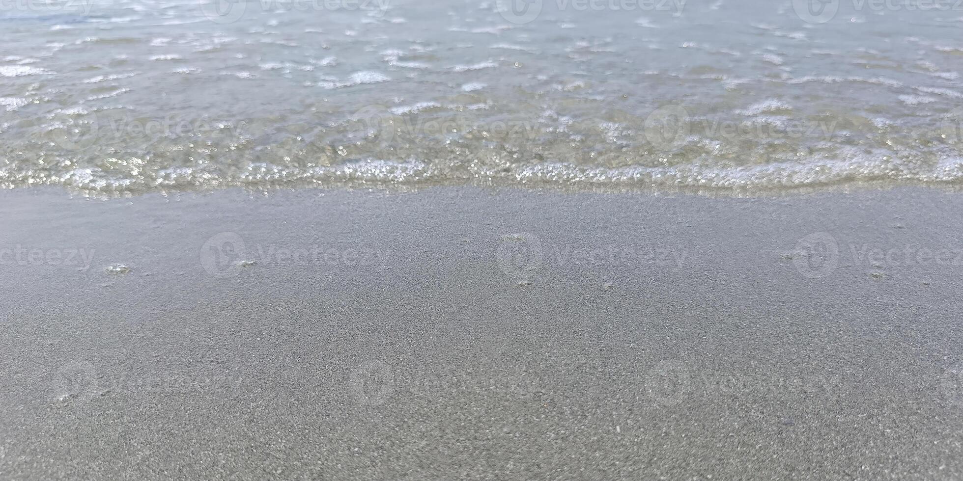 Natural background with shore water and beach sand. Summer beach calm sea photo