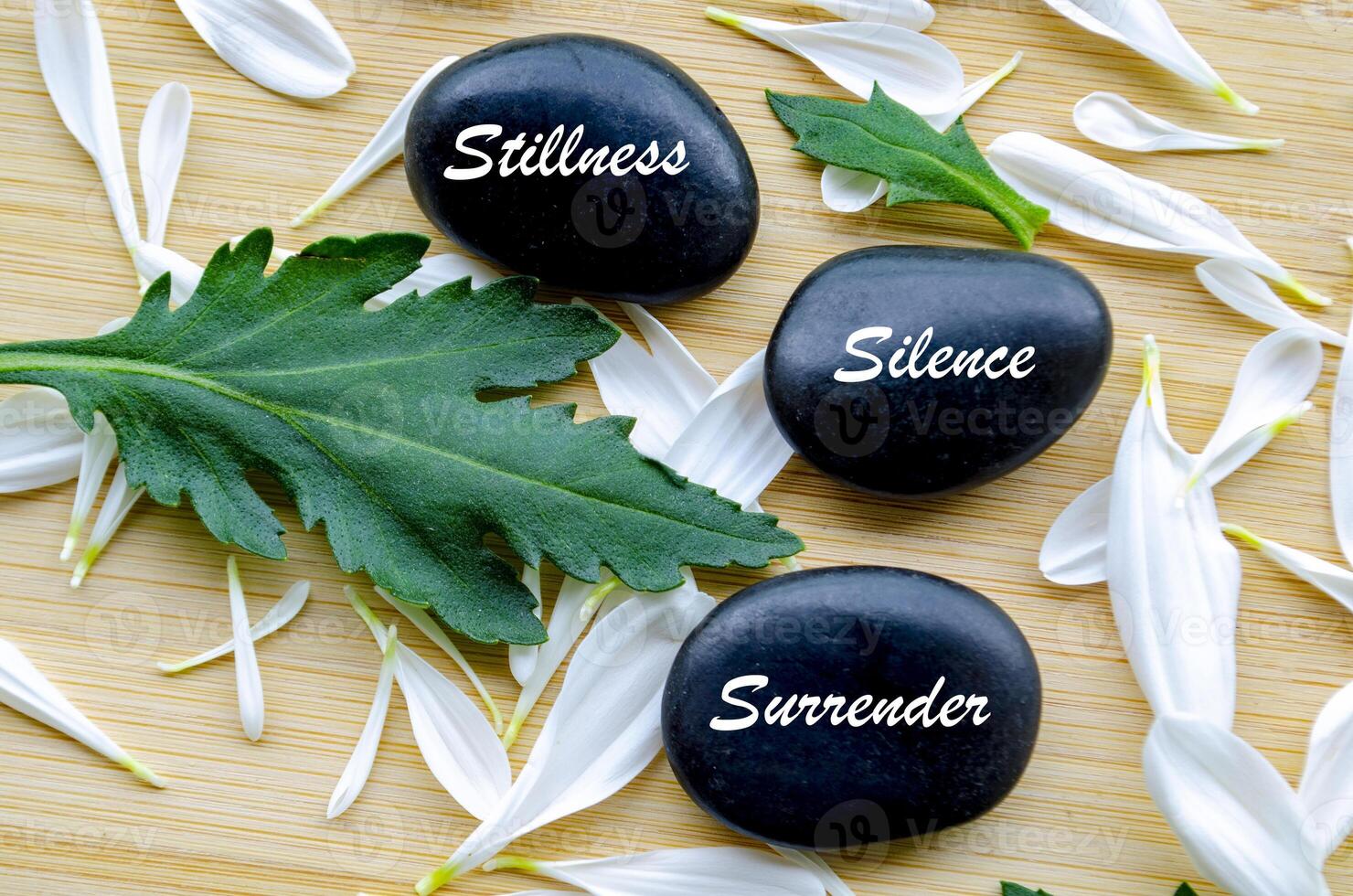 Top view of Zen stones with Stillness, Silence and Surrender text. Representing inner peace of life photo