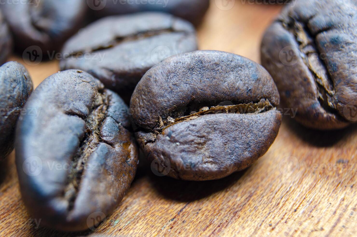 Close up of roasted coffee beans that highlights the texture and surface details of the coffee beans, with a focus on their deep brown color, natural cracks photo