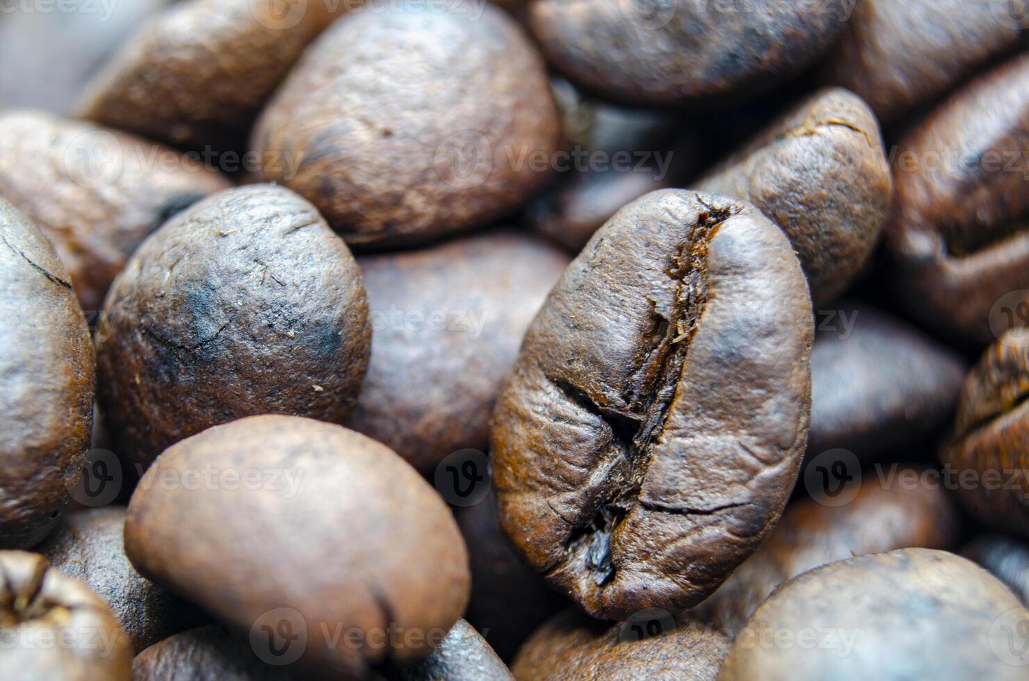 Close up of roasted coffee beans that highlights the texture and surface details of the coffee beans. Morning drinks concept photo