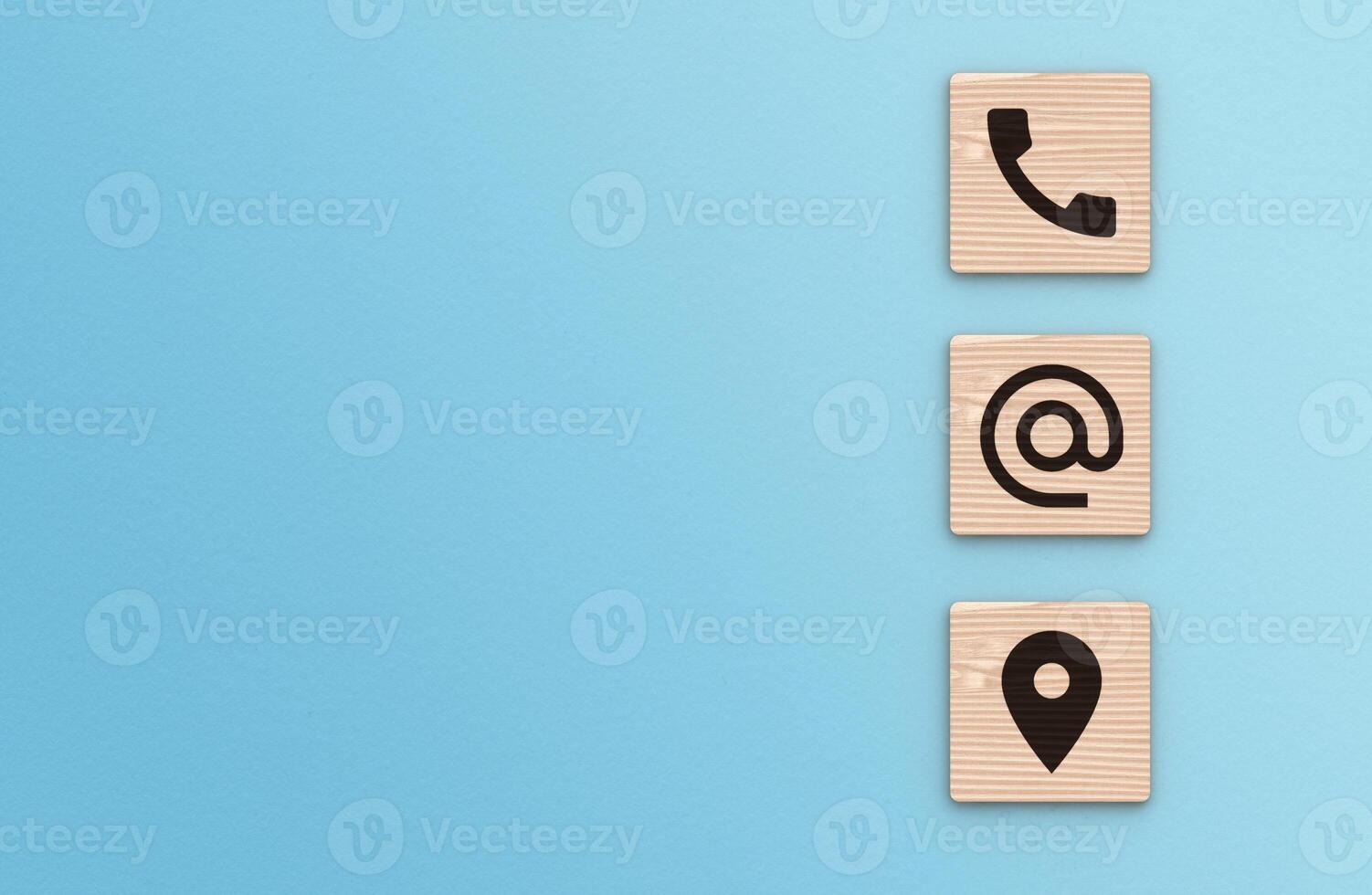 Contact Us background. Telephone, envelope letter and location icons on wooden blocks with copy space blue background photo