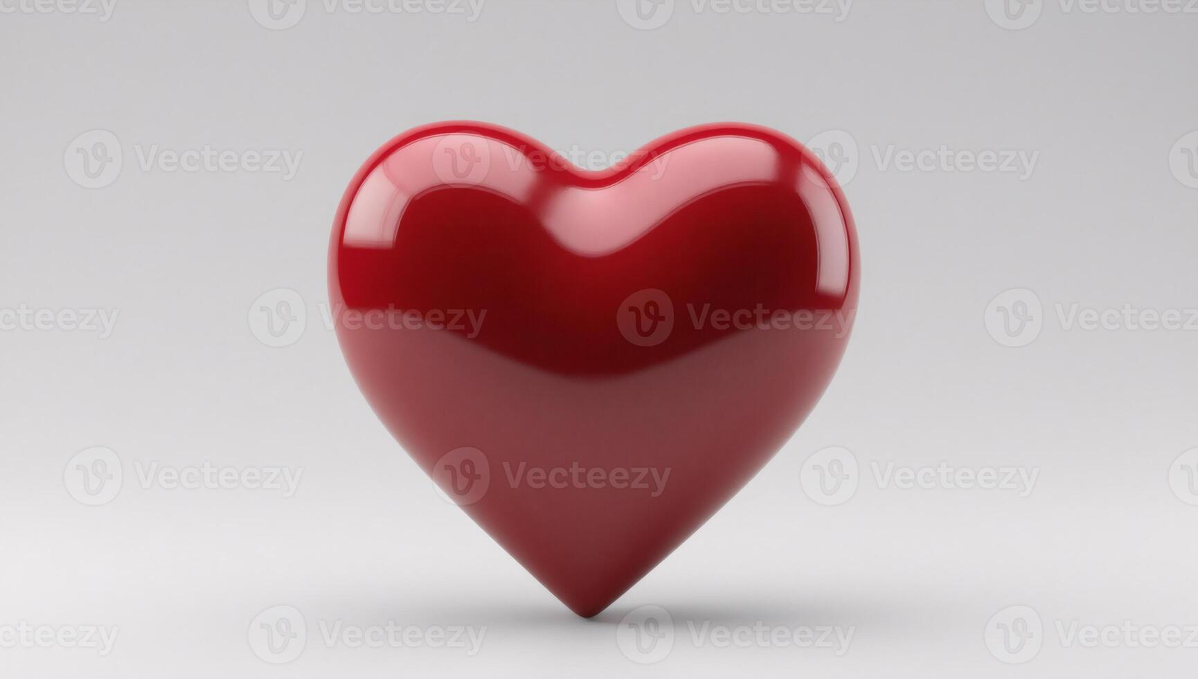 Glossy red heart shape on a simple grey background photo