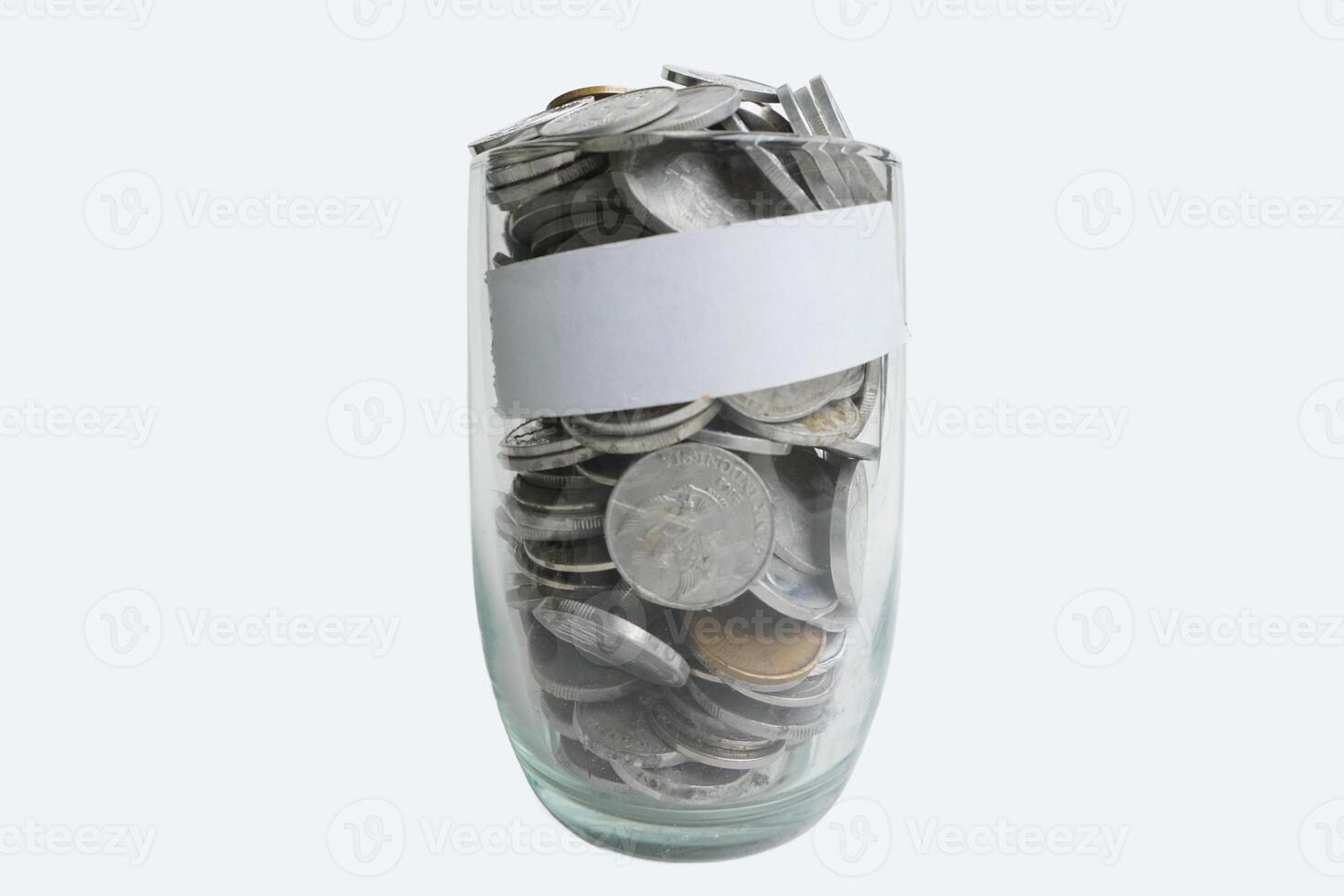 Coins rupiah in glass with white label tape on white background. Money savings concept photo
