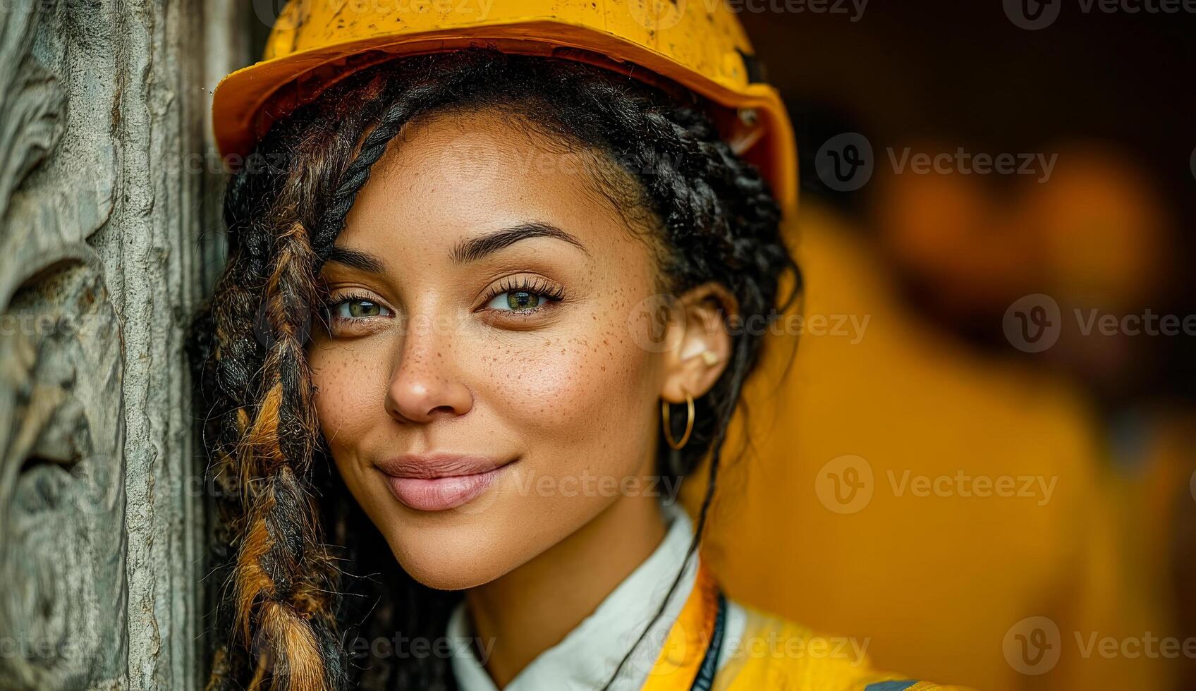 Confident smiling female worker. A woman in a yellow hard hat stands against a wooden structure, showcasing pride in her work at a construction site. photo