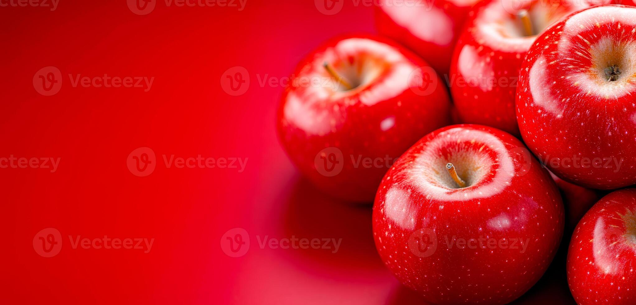 Fresh red apples on a vibrant surface. Bright red apples are grouped against a glossy red background, highlighting their shiny texture and vibrant color. photo