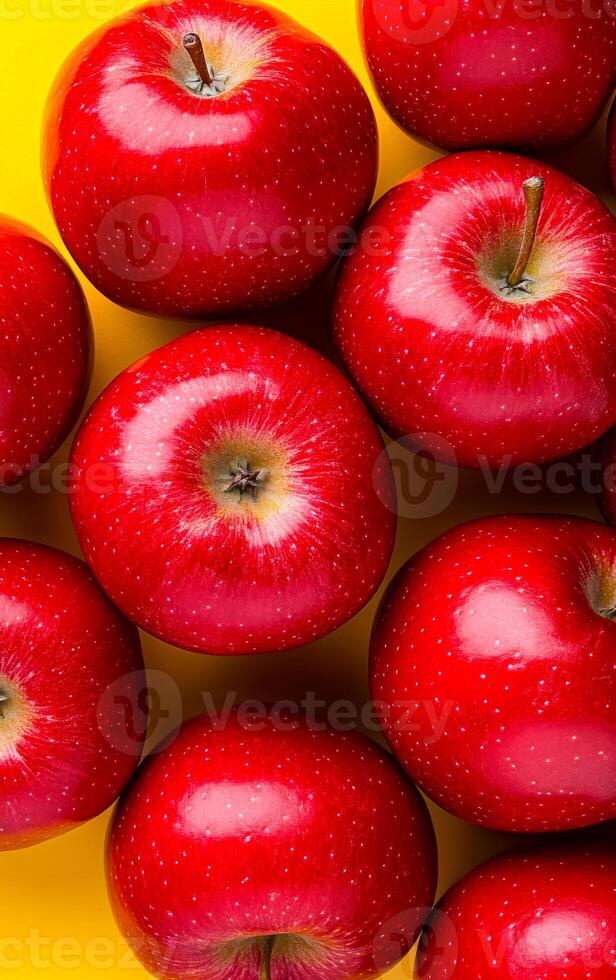 Red apples on bright backdrop. Vibrant red apples are neatly arranged on a yellow background, showcasing their shiny skin and natural beauty. photo