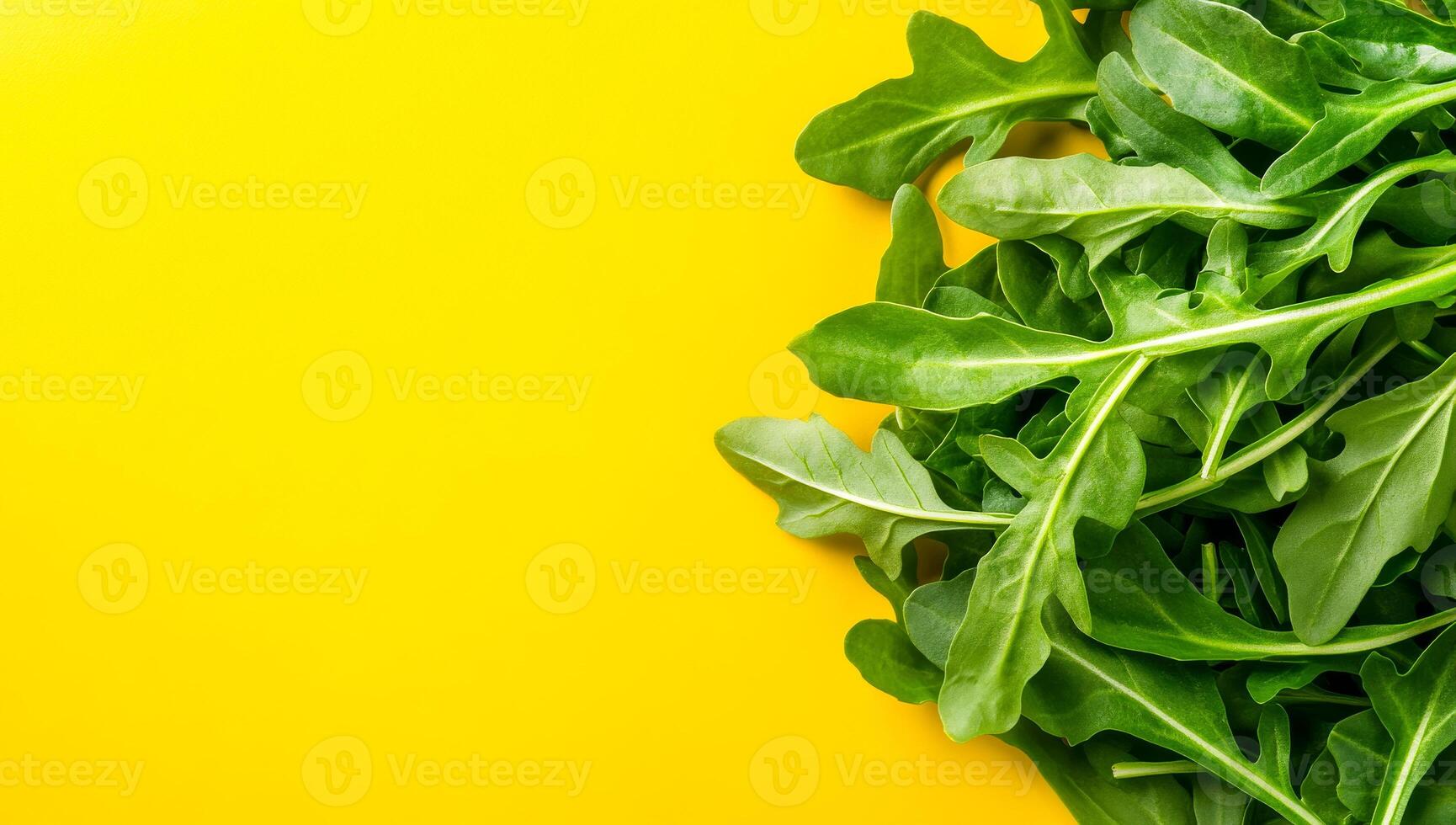 Arugula on yellow. Vibrant arugula leaves spread across a bright yellow background, showcasing their fresh and green appearance. photo