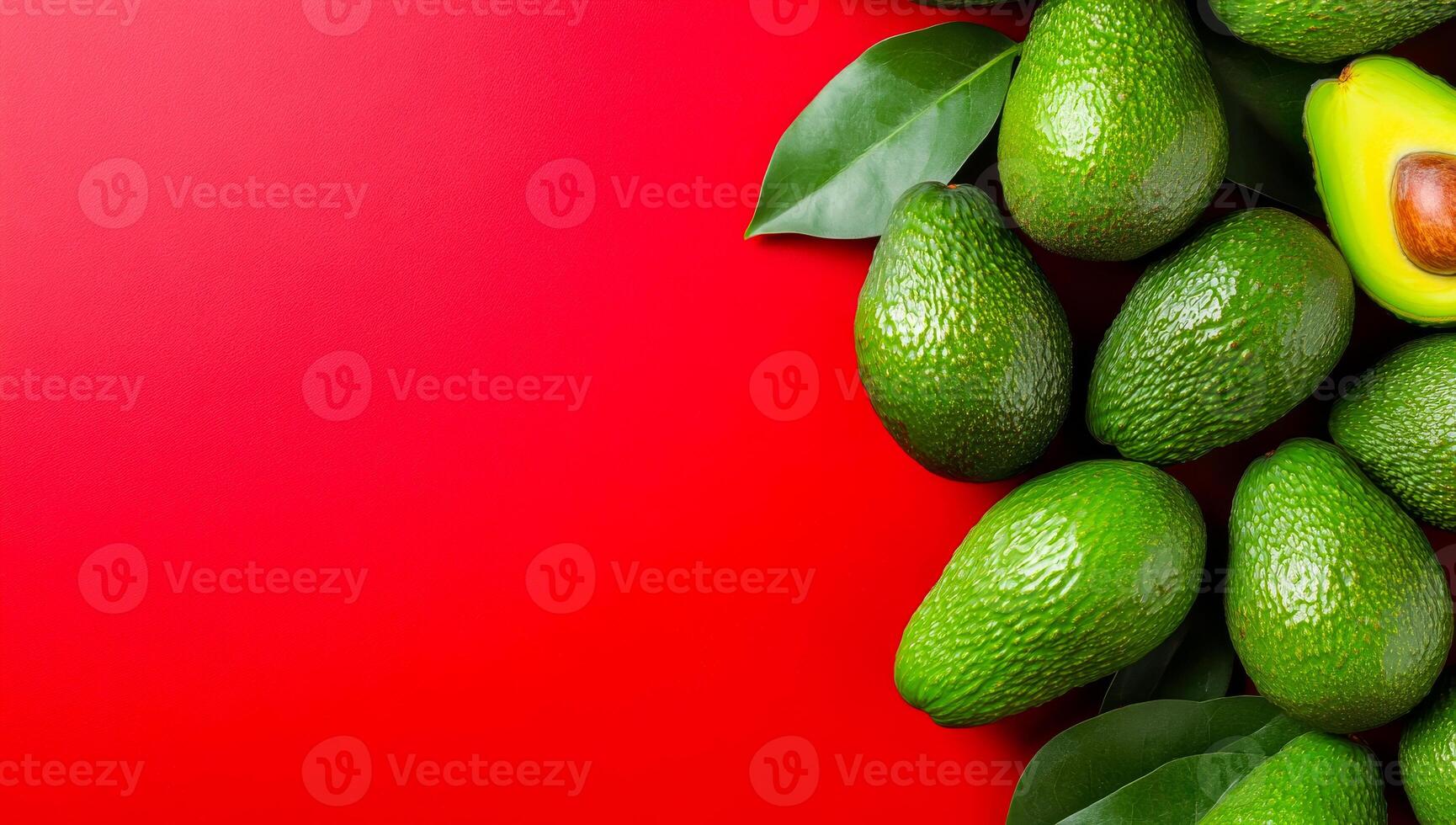 Green avocados on bright backdrop. A cluster of ripe green avocados arranged on a vibrant red surface, highlighting their natural texture and color. photo