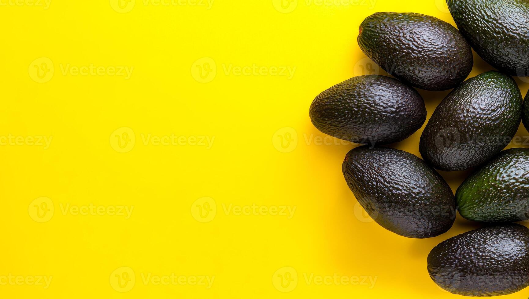 Ripe avocados on yellow. Fresh, dark green avocados are arranged artistically on a vivid yellow backdrop, showcasing their texture and color. photo