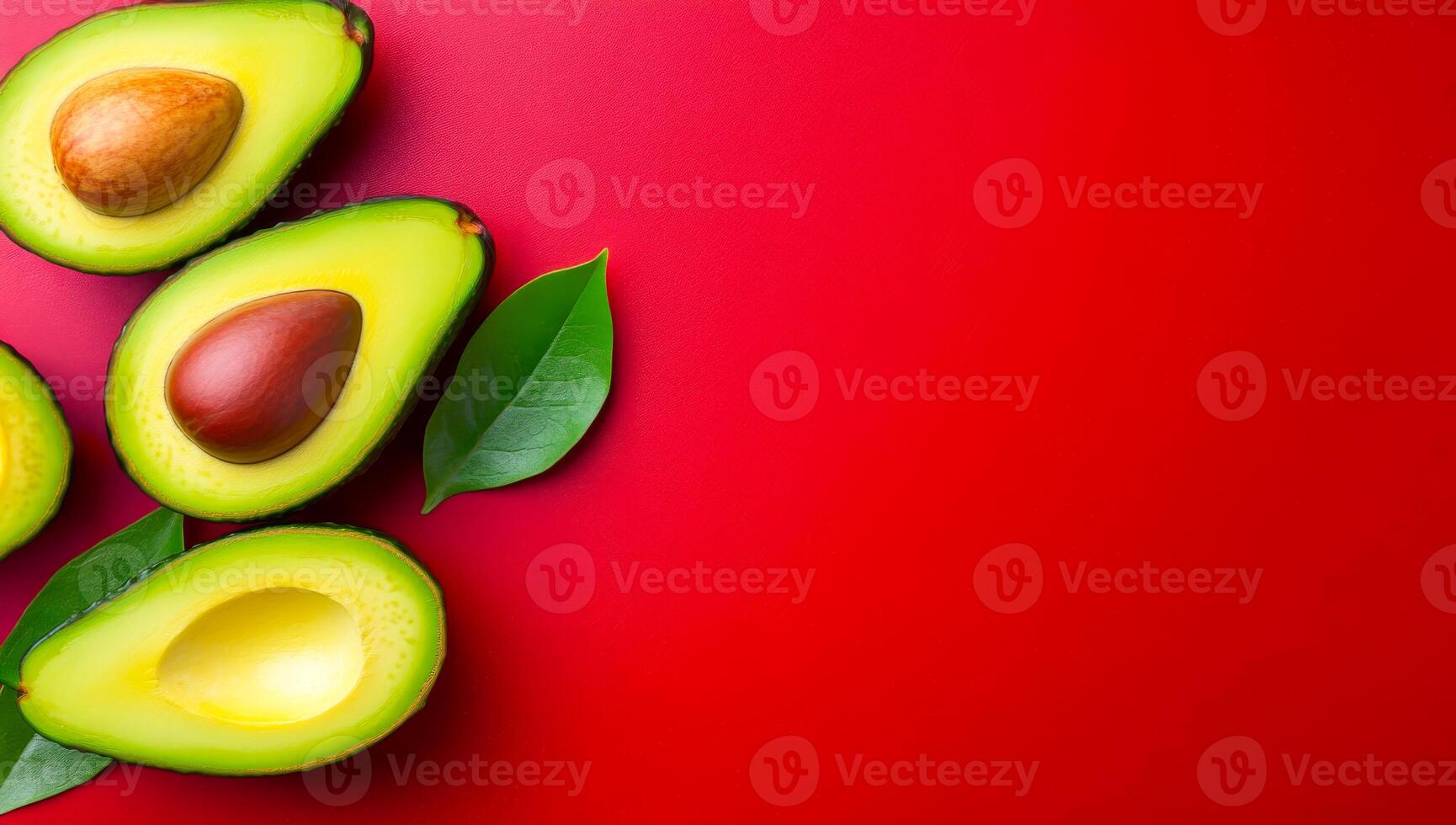 Avocados on red backdrop. Sliced avocados are displayed on a bright red surface, showcasing their colorful flesh and smooth texture. photo