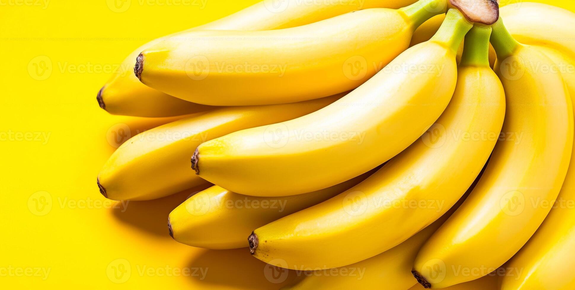 Neatly arranged yellow bananas. Fresh yellow bananas are clustered on a bright yellow background, highlighting their smooth texture. photo