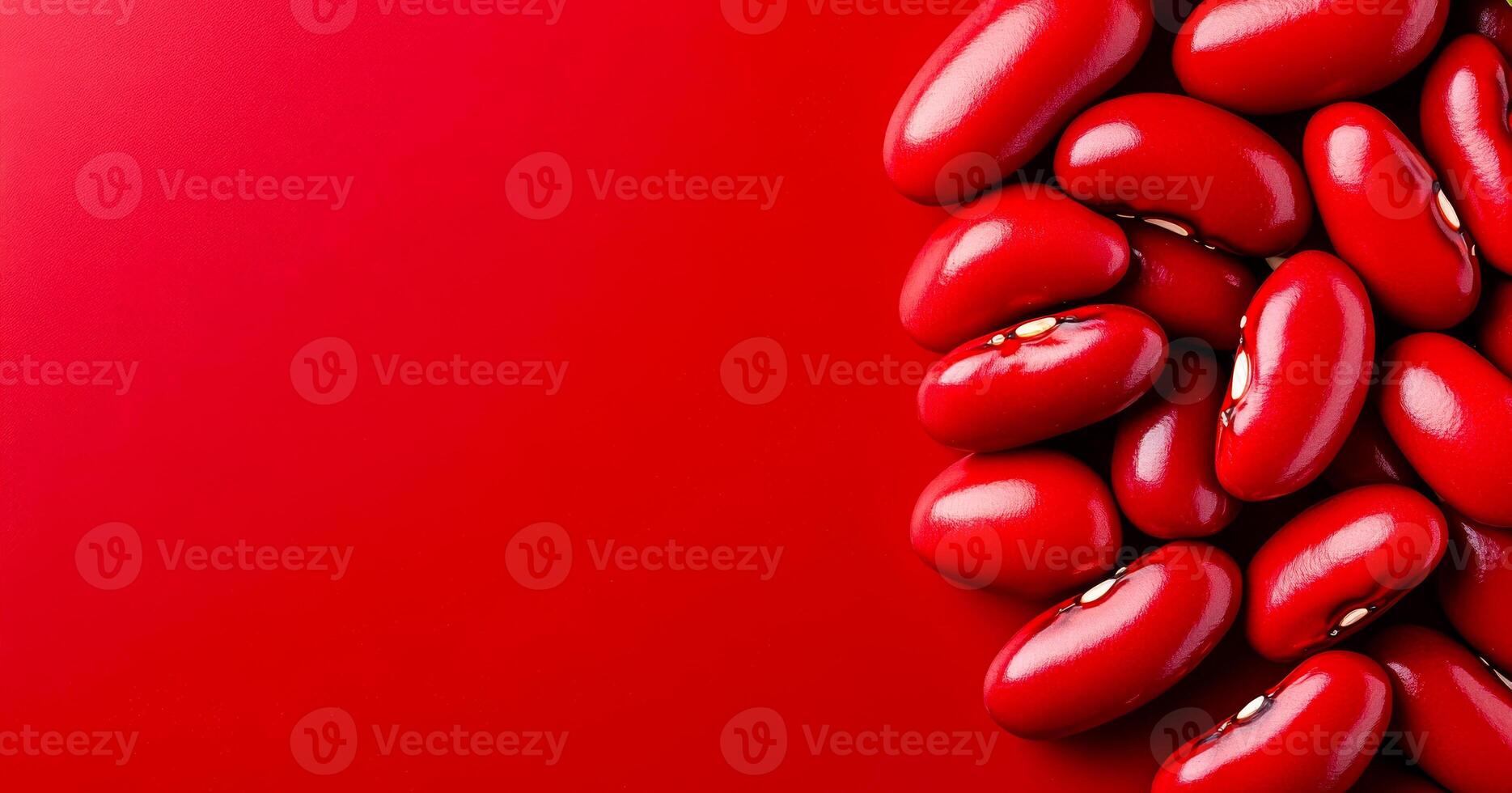 Red kidney beans on a bright background. Red kidney beans are scattered across a vibrant red surface, highlighting their smooth and shiny texture. photo