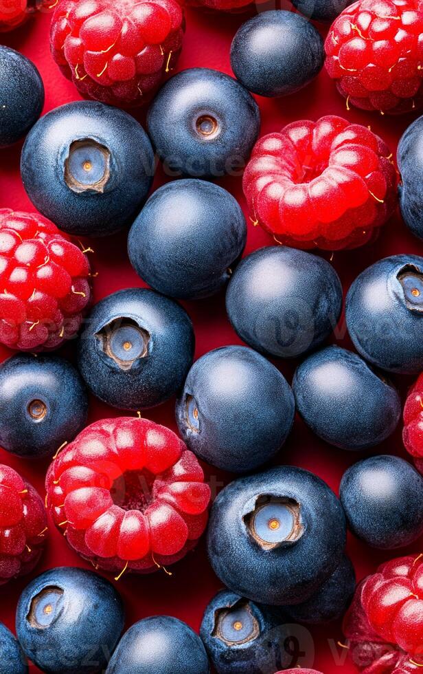 Fresh berries on a vibrant background. Bright red raspberries and deep blue blueberries are scattered, creating a colorful display of fresh fruit. photo