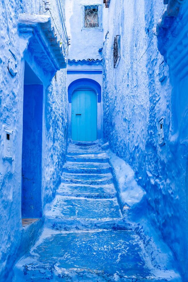 Chefchaouen, Morocco-march 26, 2024-houses, stairs, doors and windows painted entirely in blue in the town of Chefchaouen, famous for having this dominant color during a cloudy day photo