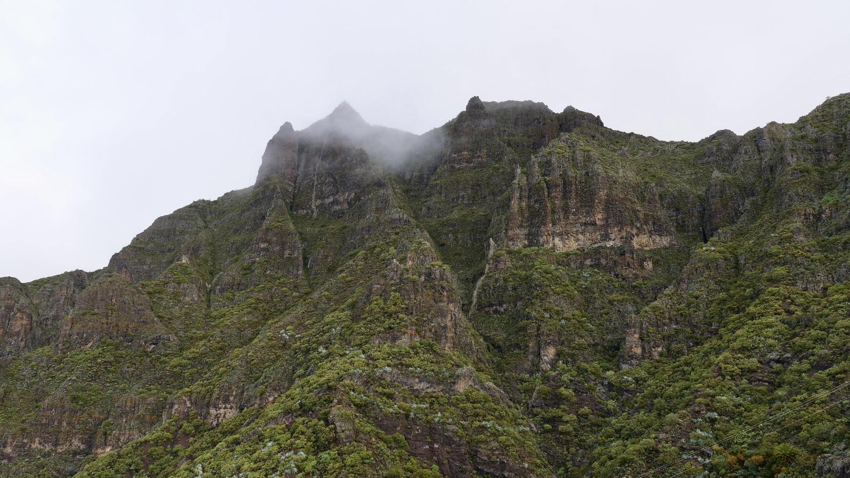 A mountain with a cloud hanging over it photo