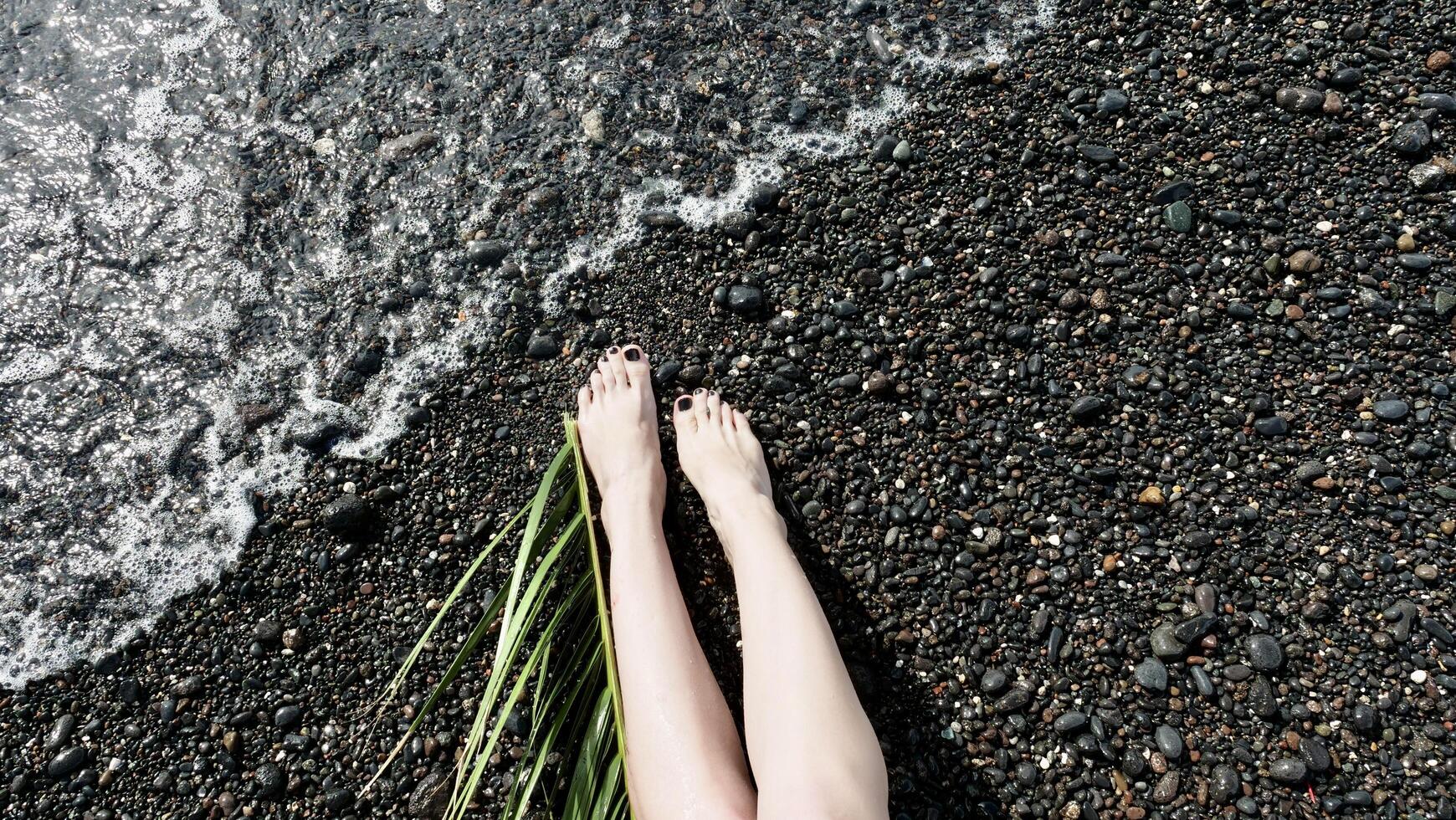 A woman's legs on the beach with grass photo