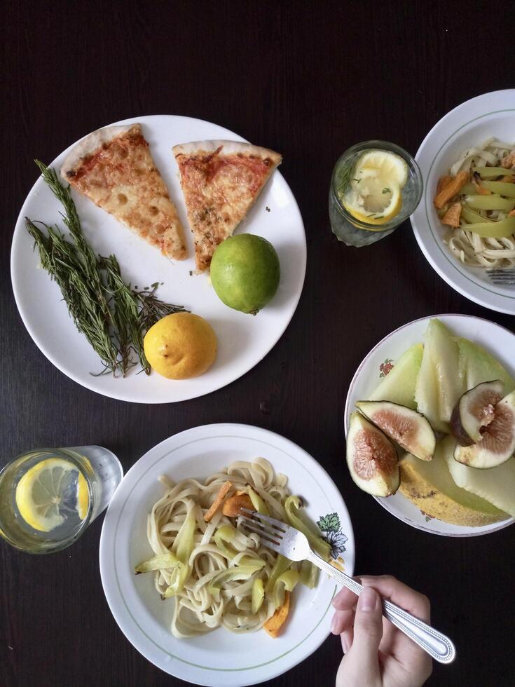 A table with plates of food and a person holding a fork photo