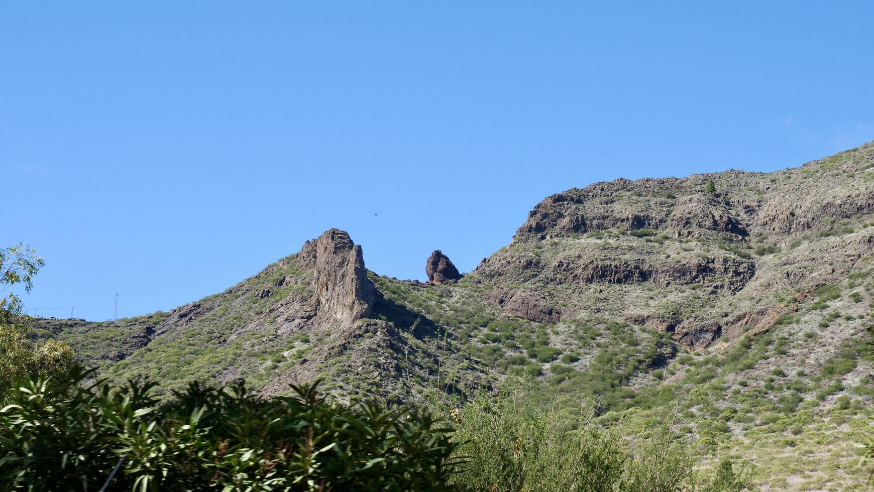 A mountain with a clock tower on top photo