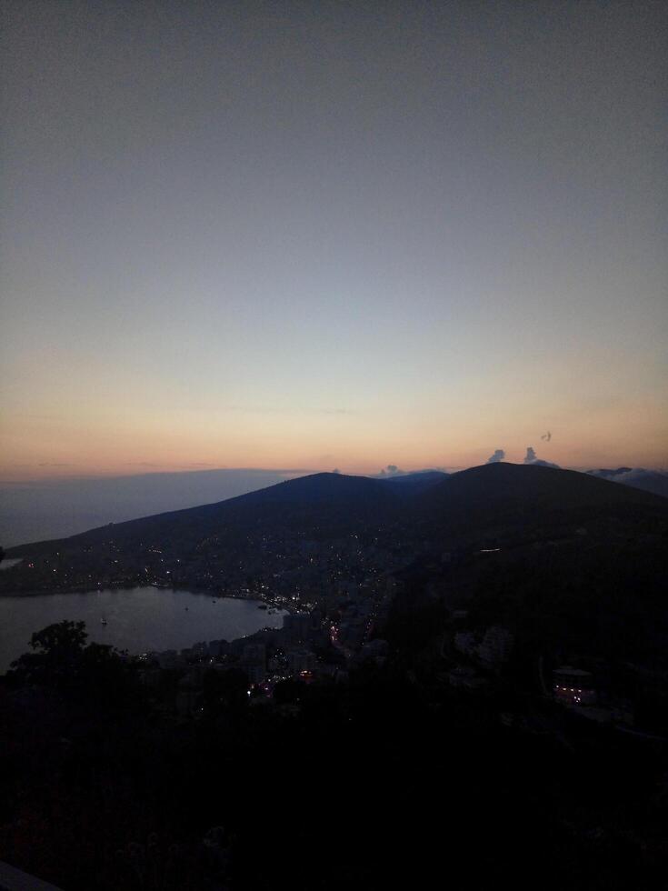 A view of a city at dusk from a hill photo