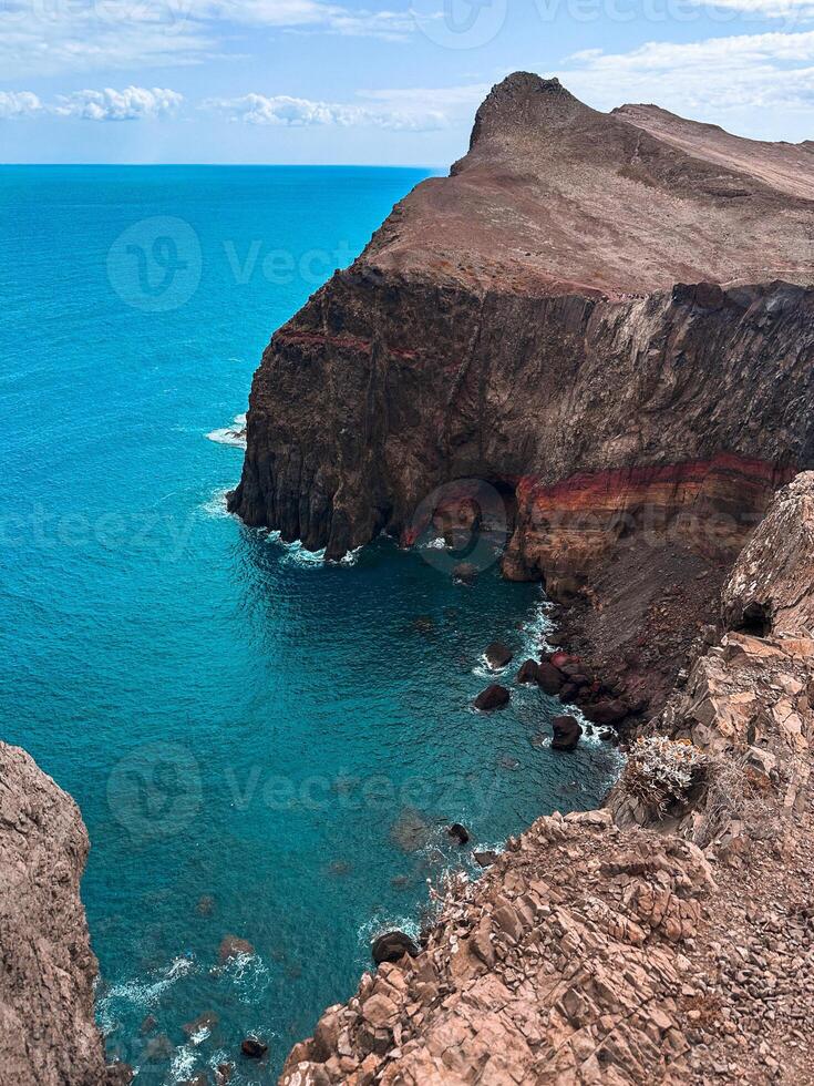 Madeira island PR8 Portugal hills aerial view from cliff to Atlantic Ocean blue water shore seascape rocks geology lagoon stream rough mountain scenery vacation hiking trail sightseeing vertical photo