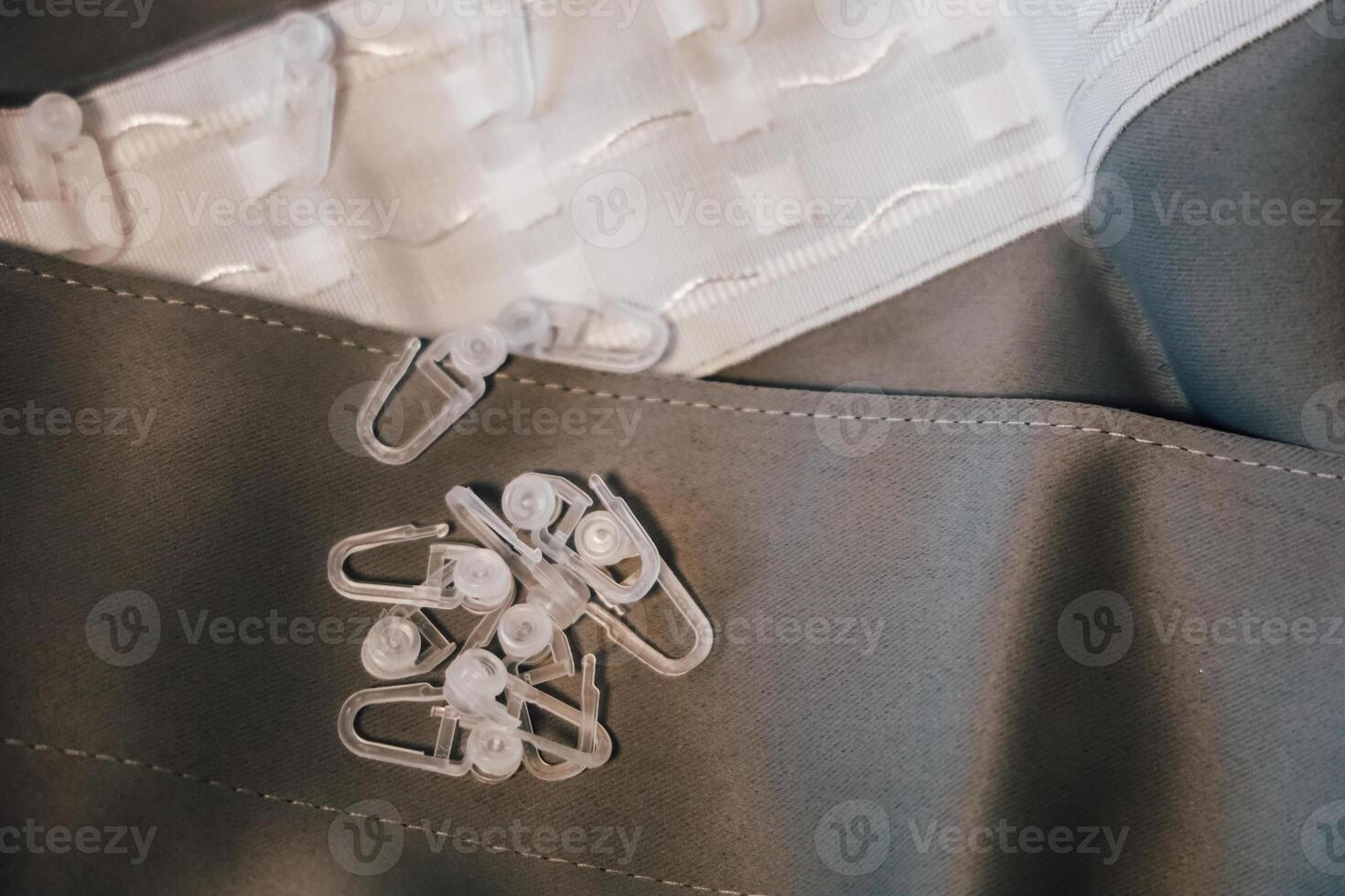 Clear plastic clips for curtains and fabric materials arranged for a sewing project at a creative workspace photo