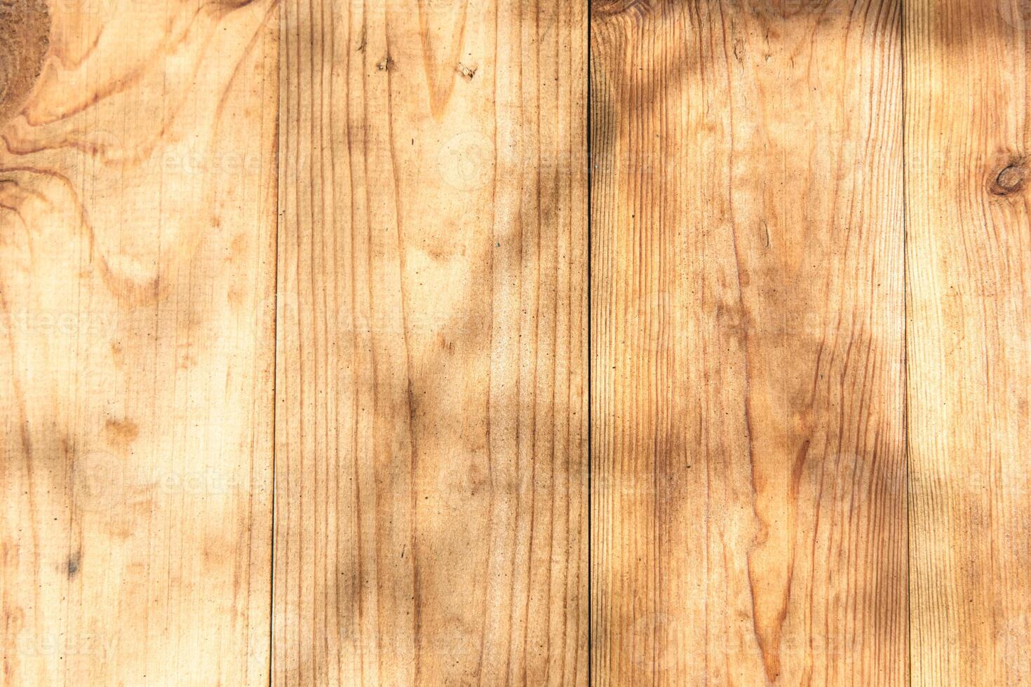 Natural wood surface with shadows highlighting texture and grain patterns in sunny light photo