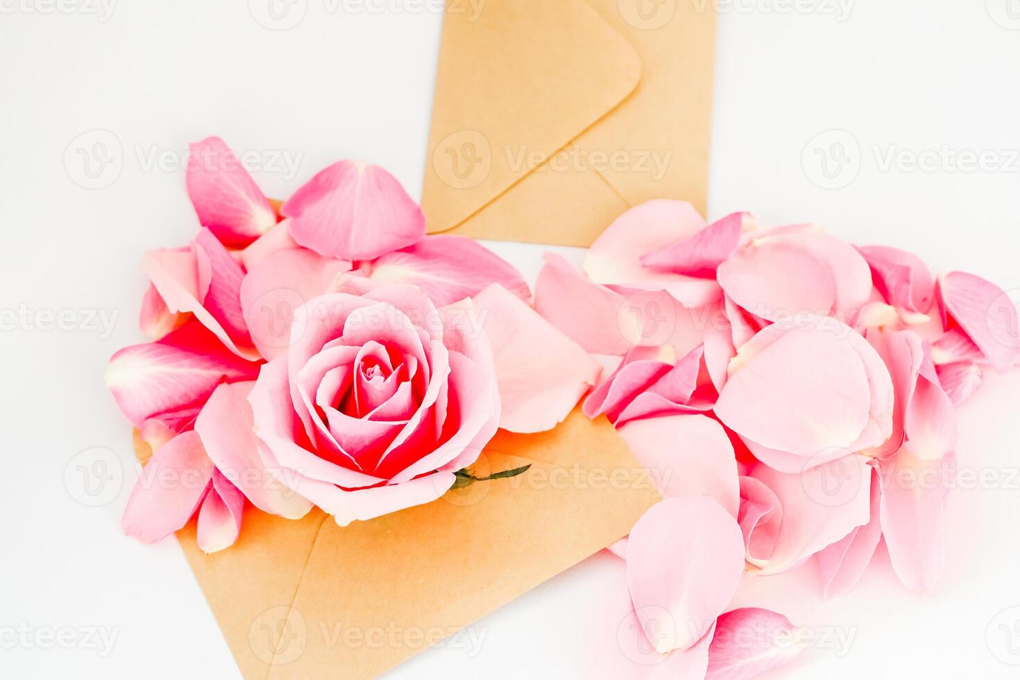 Couple of envelopes with pink rose and petals arranged for a romantic occasion photo