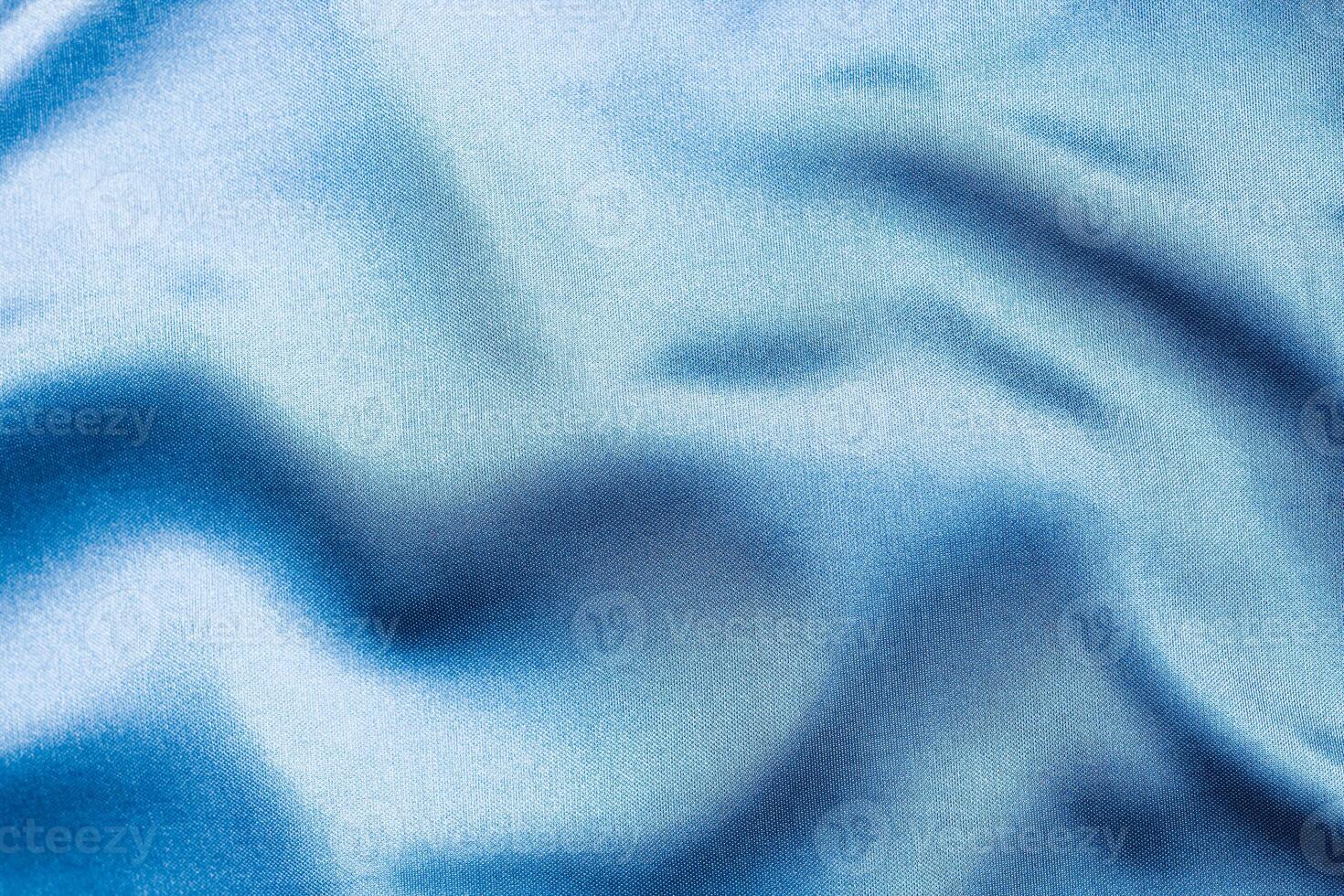 Silky blue fabric draped to showcase smooth texture and color depth photo