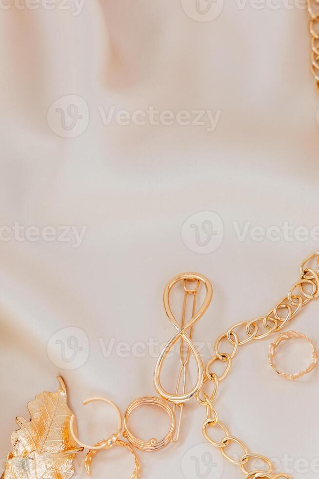 Golden jewelry accessories arranged on soft fabric background for elegant display photo