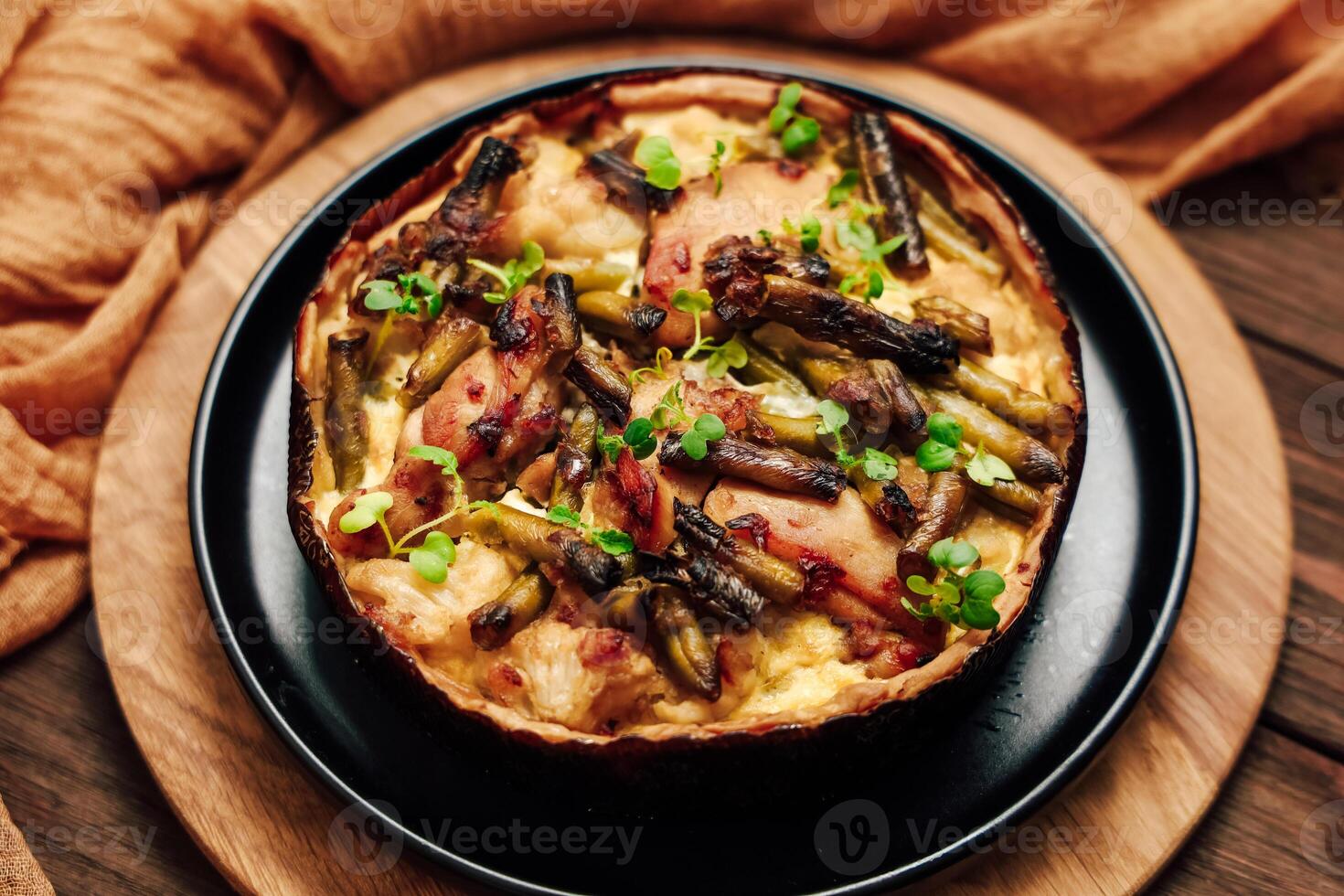 Savoring a freshly baked quiche with asparagus and herbs on a rustic wooden table photo