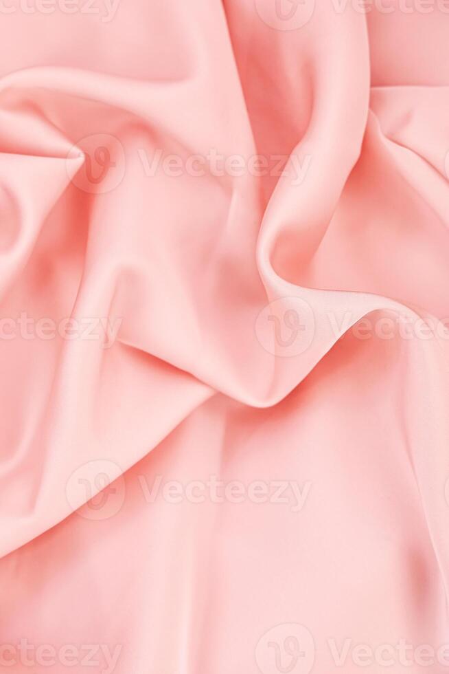 Soft pink fabric creating gentle folds and waves under bright lighting in a textile studio photo
