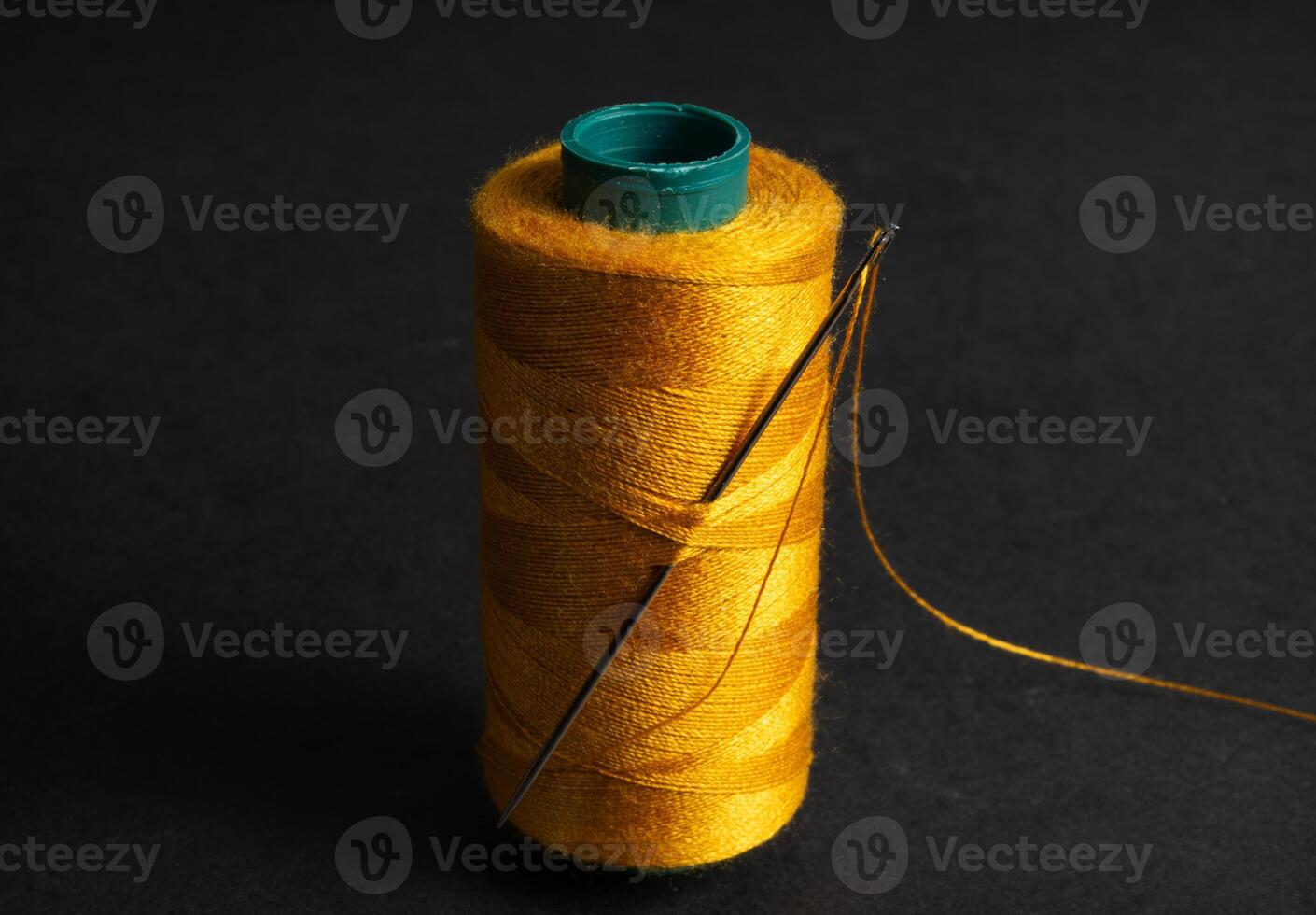 single golden thread spool with needle photo