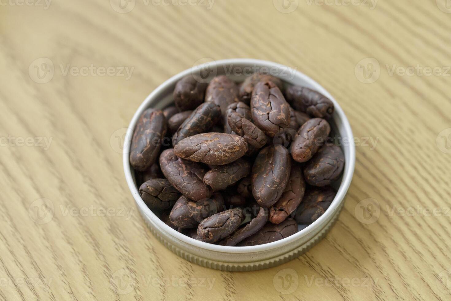 Pile of cocoa nibs on a wooden table photo