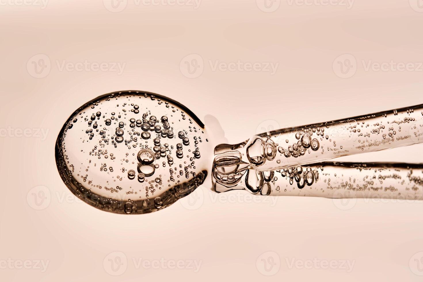A serum pipette with bubbles on a beige background. photo