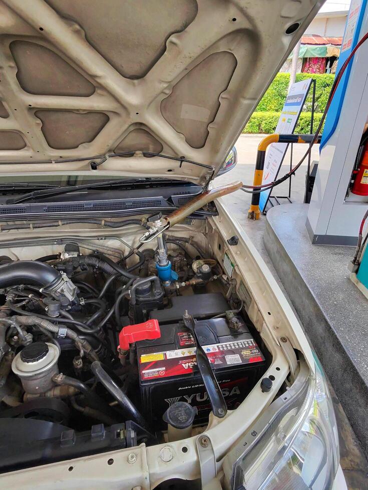 Bangkok, Thailand-May 21, 2025 Close up car or truck opening front hood to fill NGV or Natural Gas for Vehicle at gas station. Need Energy, Transportation and Power for driving. photo