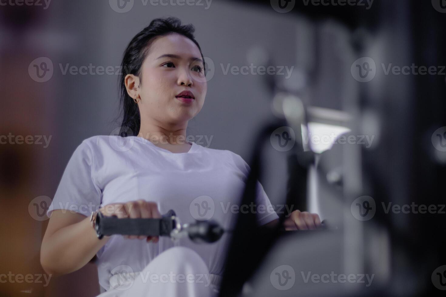 Dedicated Female Athlete Engages in Rowing Machine Workout Routi photo