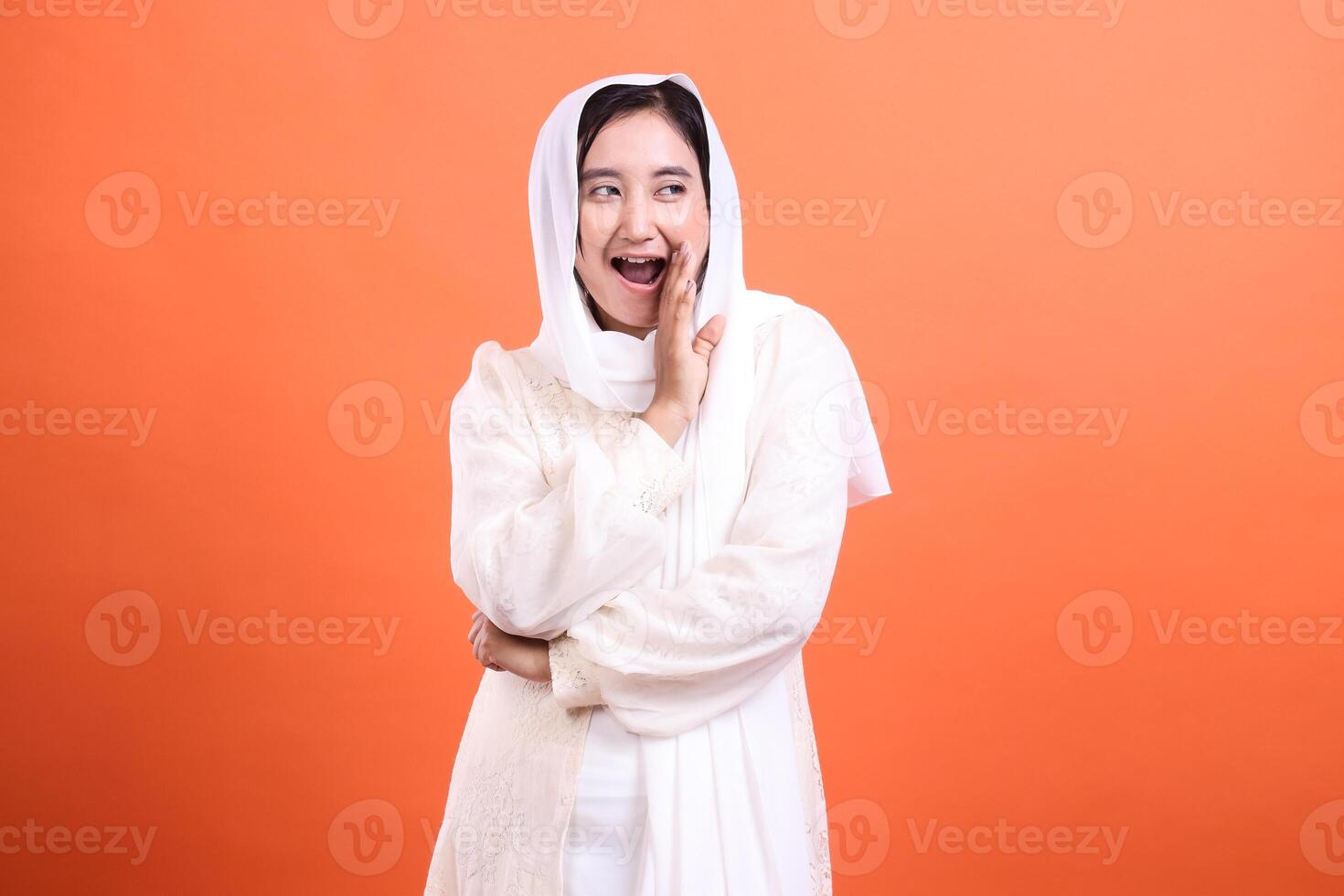 Excited Young Woman in Hijab Sharing a Secret, Portraying Joyful photo
