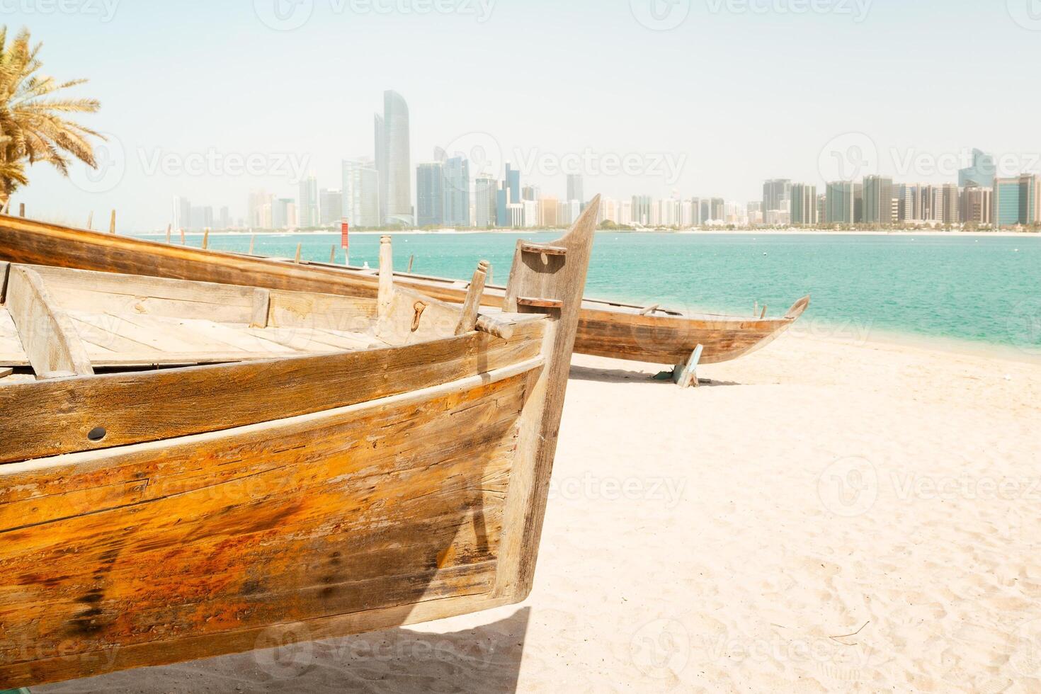 Abu Dhabi skyline with old traditional fishing boats in Heritage Village in Abu Dhabi in United Arab Emirates UAE. Couple tourist enjoy beach and visit sightseeing travel destination in UAE photo