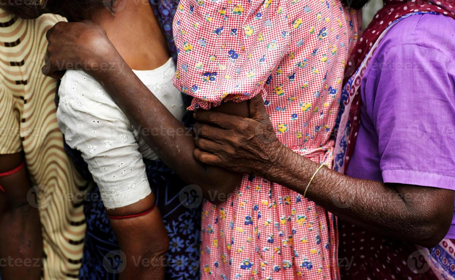 Women Supporting Each Other While Queuing for Aid in a Refugee Camp photo
